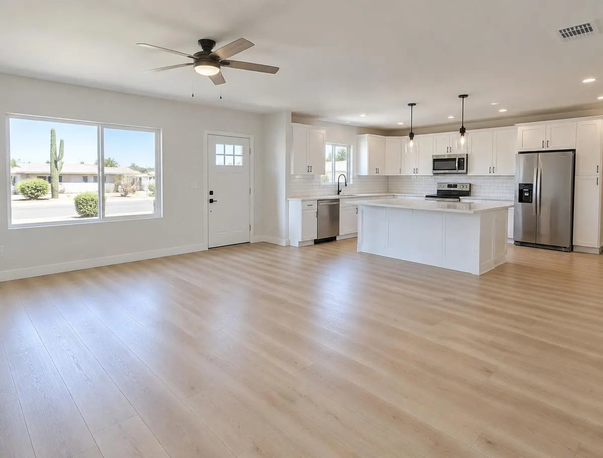 Finished living room and kitchen with new flooring and white cabinets, ready to list