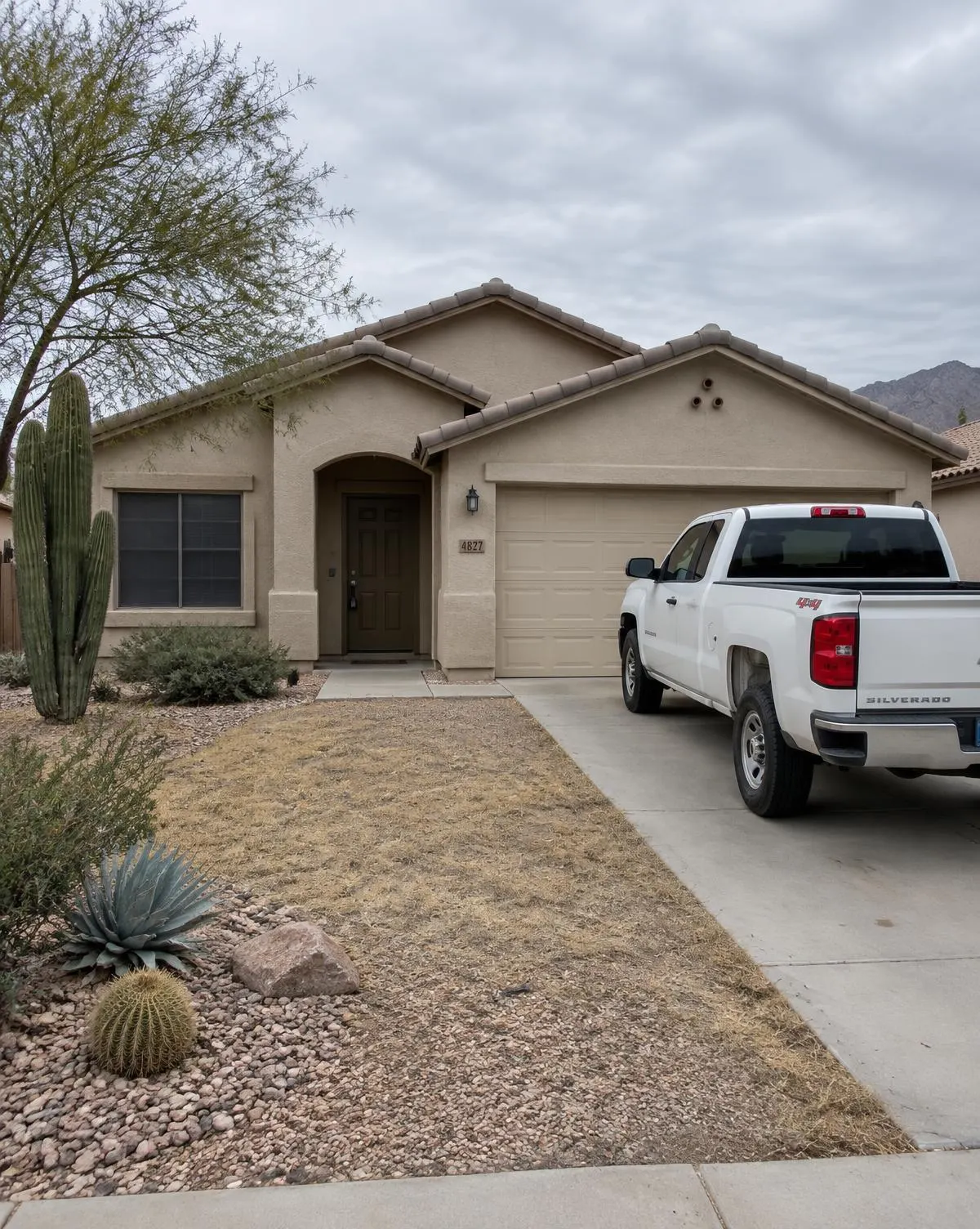 Vacant stucco home with a work truck parked in the driveway